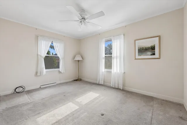 an empty room with windows and cabinet