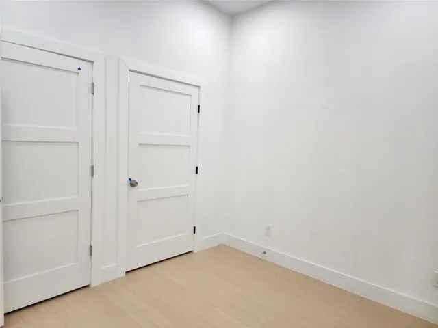 a view of an empty room with chandelier and a window