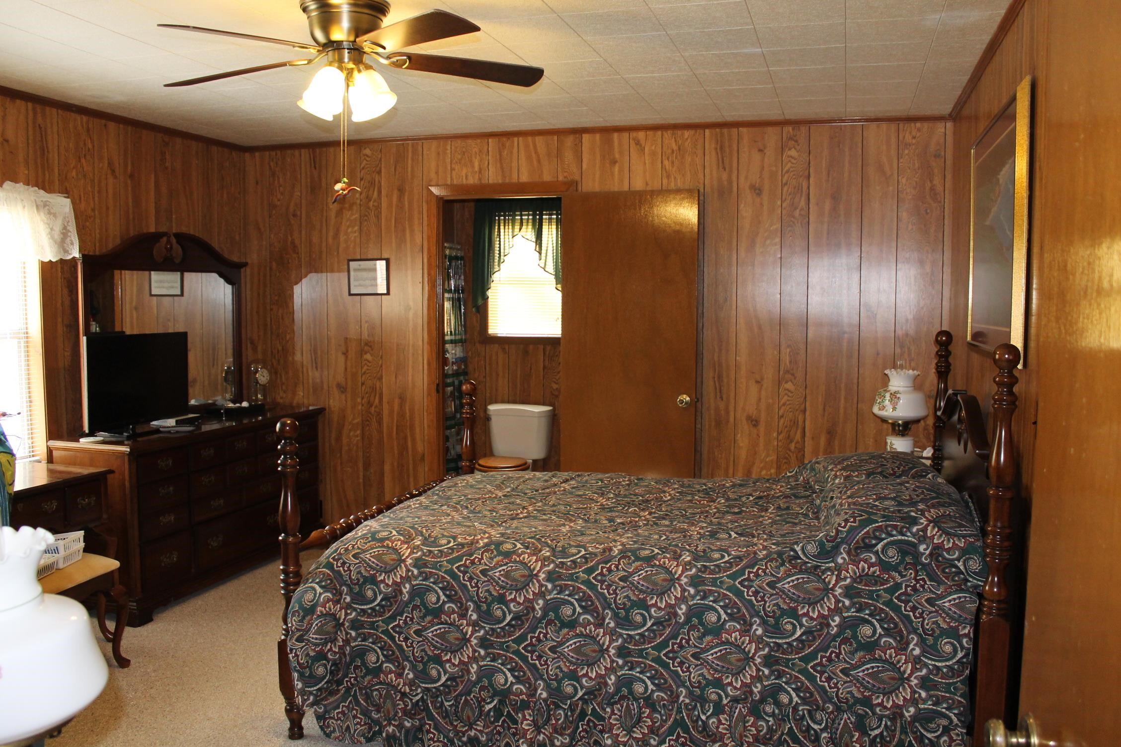 260 Bluebird Road Counce, TN 38326 - Photo 7 of 15 a bedroom with a bed and a chandelier