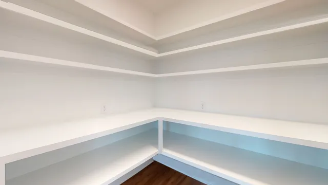 an empty room with wooden floor chandelier fan and windows