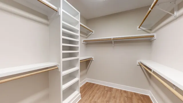 a view of an empty room and chandelier fan
