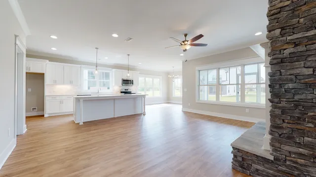 a large kitchen with stainless steel appliances kitchen island a large counter top and a wooden floors