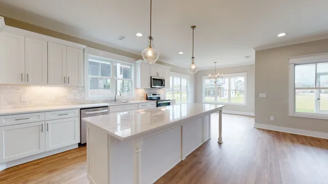 a kitchen with stainless steel appliances granite countertop a sink a stove and a wooden floor