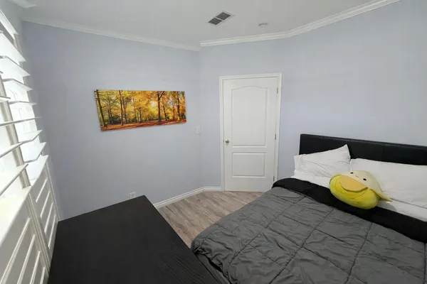 a bedroom with a bed and wooden floor