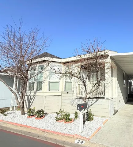 a view of a white building among the street with palm trees