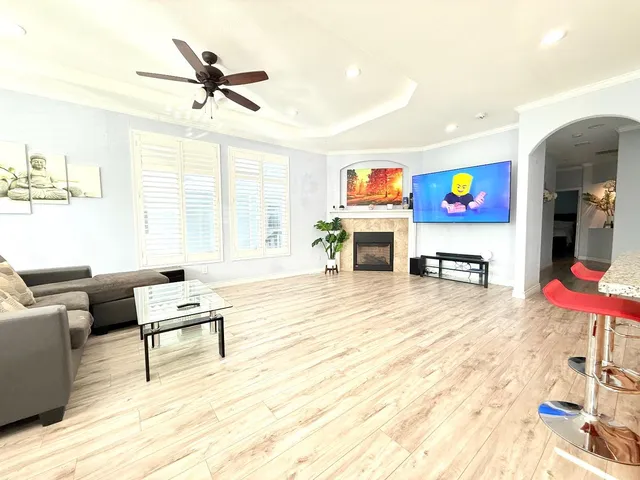 a living room with furniture and a flat screen tv with wooden floor