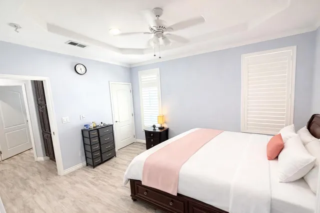 a bedroom with a bed dresser and a large window