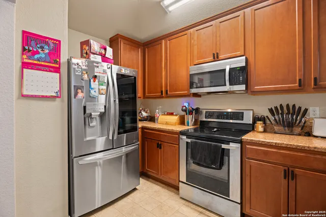 a kitchen with stainless steel appliances granite countertop a refrigerator and a stove top oven