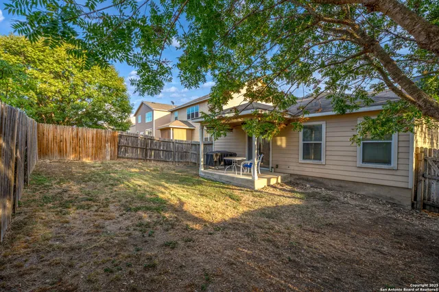 a view of a house with backyard and sitting area
