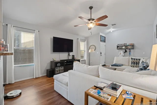 a living room with furniture a flat screen tv and a window