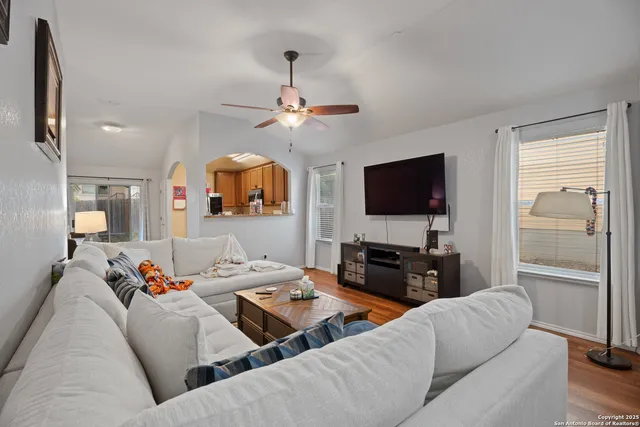 a living room with furniture a flat screen tv and kitchen view
