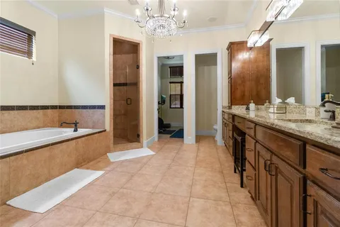 a large bathroom with a tub sink shower and mirror