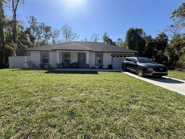 a view of a house with a yard and sitting area