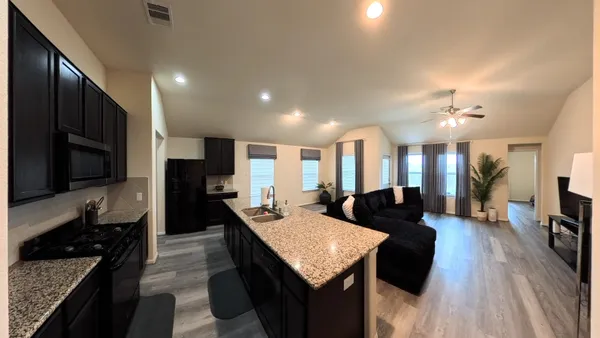 a large kitchen with stainless steel appliances kitchen island granite countertop a large island in the center