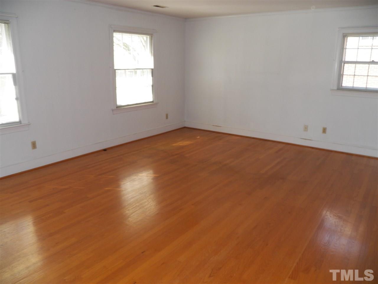 4704 Stiller Street Raleigh, NC 27609 - Photo 16 of 25 an empty room with wooden floor and windows