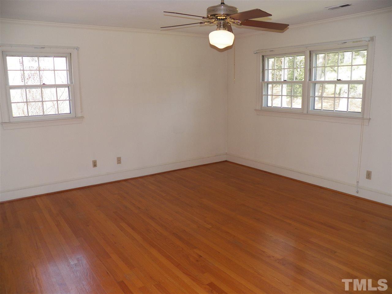 4704 Stiller Street Raleigh, NC 27609 - Photo 19 of 25 an empty room with wooden floor and windows