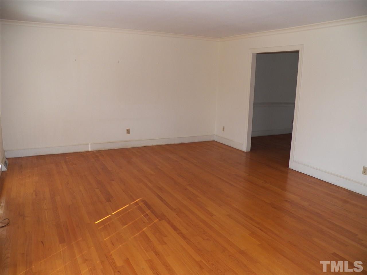4704 Stiller Street Raleigh, NC 27609 - Photo 4 of 25 an empty room with wooden floor and windows