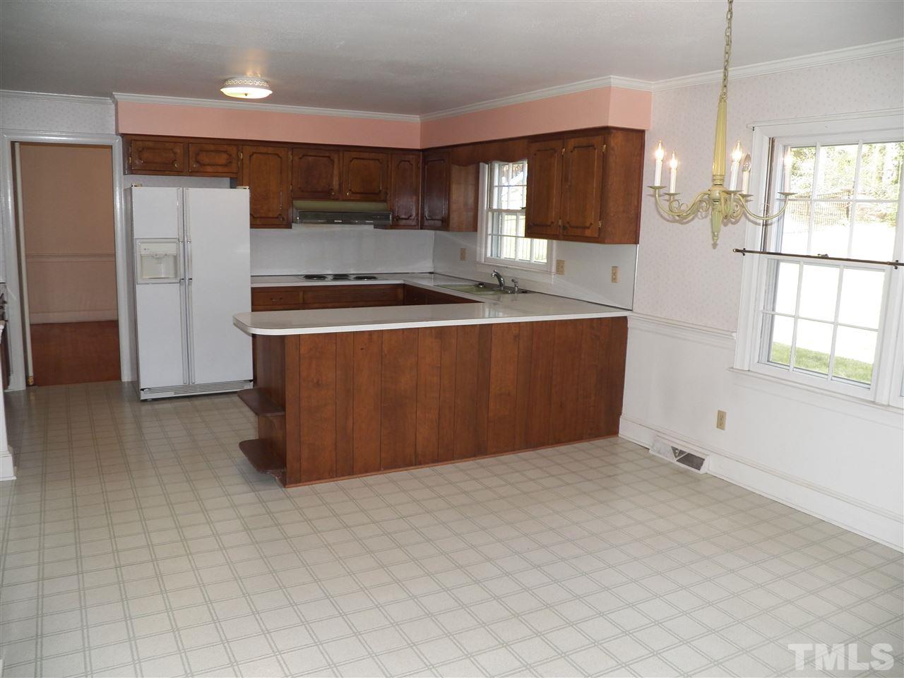 4704 Stiller Street Raleigh, NC 27609 - Photo 7 of 25 a kitchen with stainless steel appliances a refrigerator a sink a stove a microwave a counter top and cabinets
