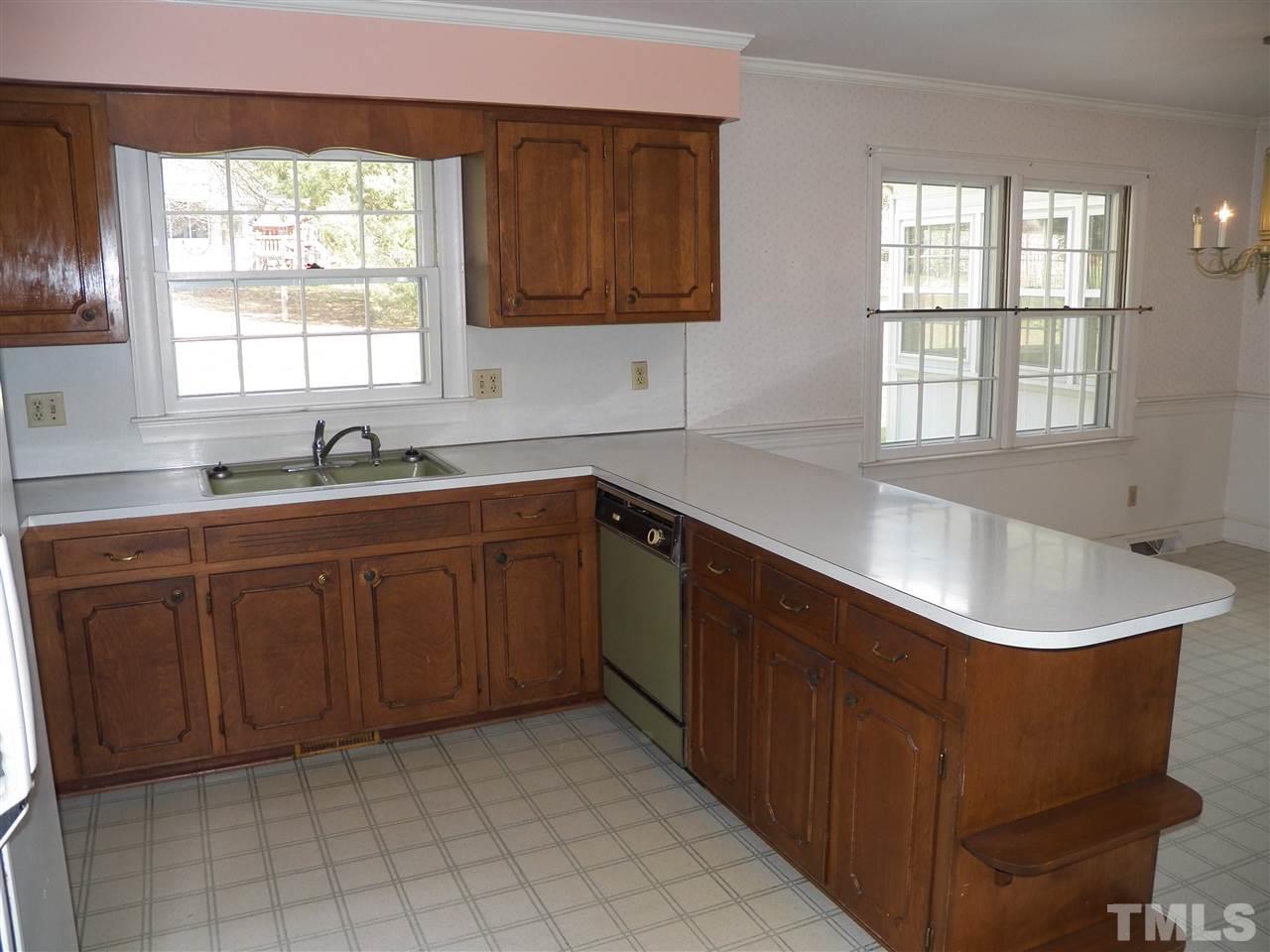 4704 Stiller Street Raleigh, NC 27609 - Photo 9 of 25 a kitchen with a sink window and cabinets
