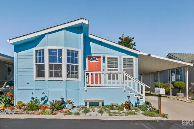a front view of a house with a yard and potted plants