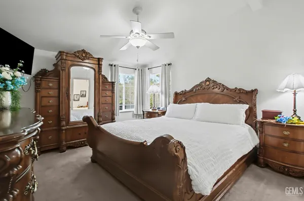 a spacious bedroom with a bed and a chandelier