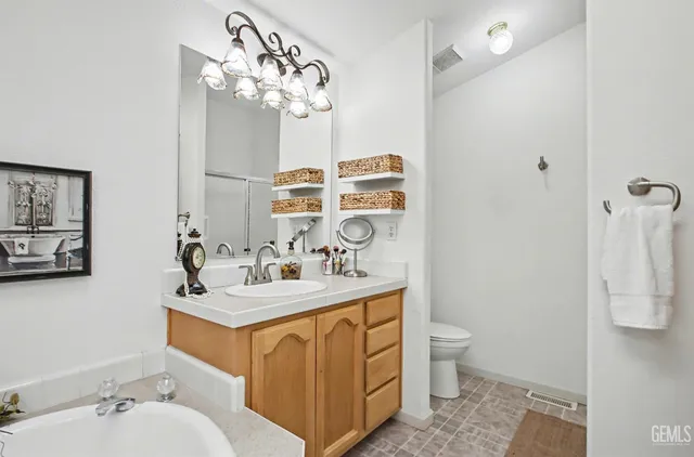 a bathroom with a sink vanity mirror and toilet