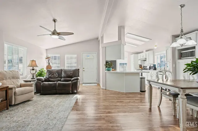 a living room with furniture a chandelier and wooden floor