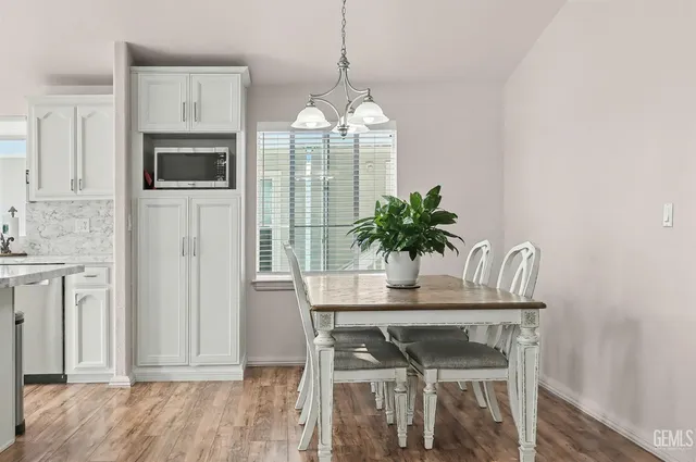 a dining room with furniture potted plants and wooden floor