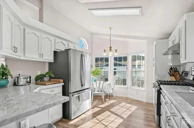 a kitchen with stainless steel appliances granite countertop a refrigerator and a stove