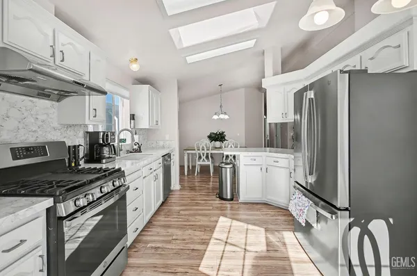 a kitchen with a refrigerator a sink and cabinets