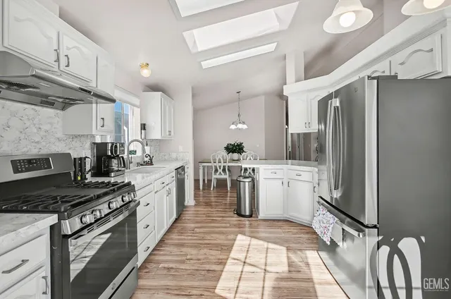 a kitchen with a refrigerator a sink and cabinets