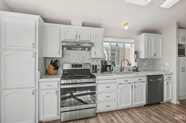 a kitchen with white cabinets and appliances