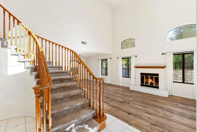a view of a livingroom with wooden floor and a fireplace