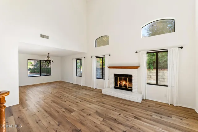 a view of an empty room with window and fire place