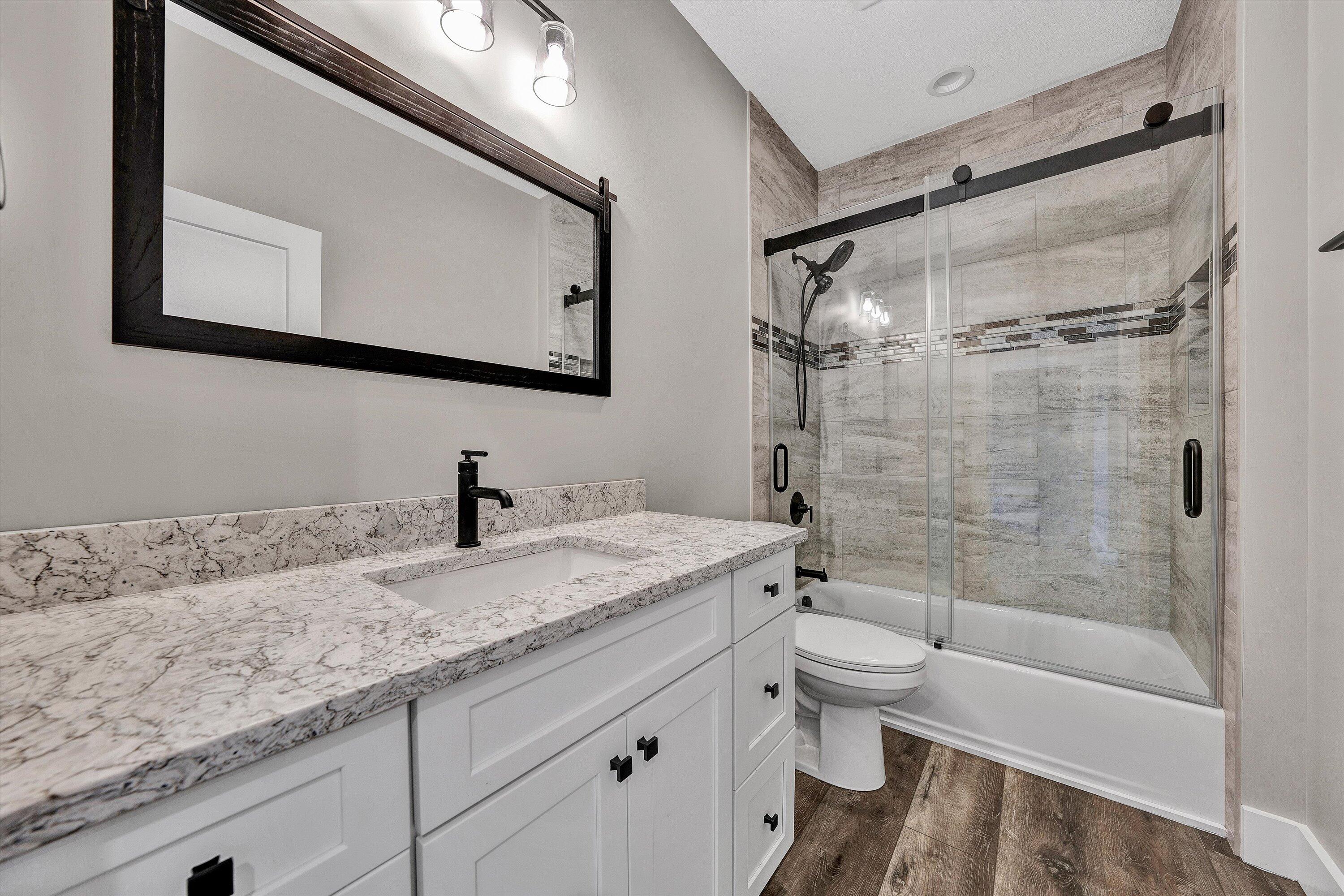 6450 Scruggs Road Moneta, VA 24121 - Photo 12 of 42 a bathroom with a granite countertop sink toilet and shower