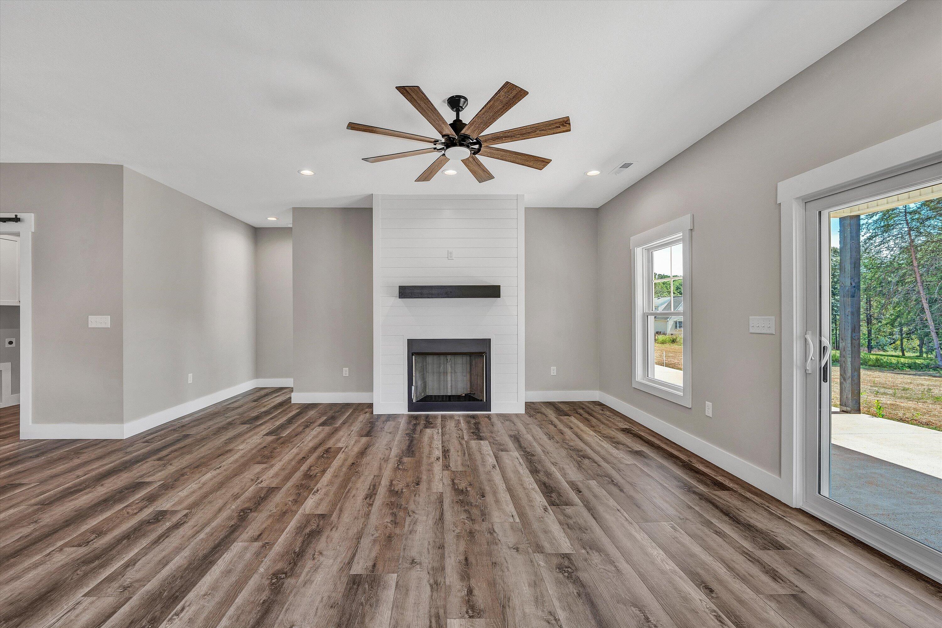 6450 Scruggs Road Moneta, VA 24121 - Photo 21 of 42 a view of a livingroom with a fireplace a ceiling fan and windows