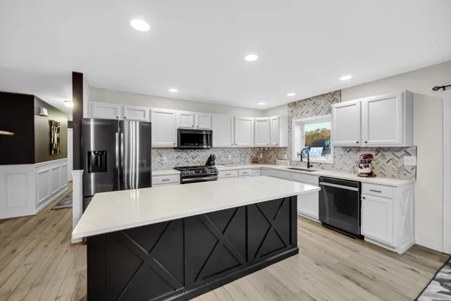 a kitchen with stainless steel appliances a stove sink microwave and cabinets
