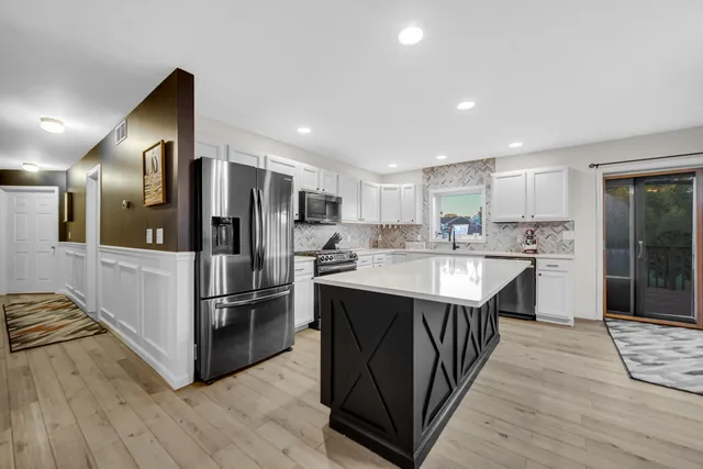 a kitchen with stainless steel appliances granite countertop a refrigerator and a stove