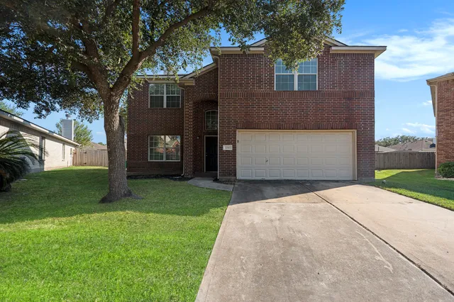 front view of a house with a yard and an trees