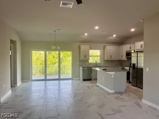 a view of a kitchen with a sink and dishwasher a refrigerator with white cabinets