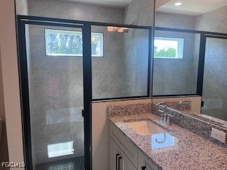 14058 Pacosin Court Bokeelia, FL 33922 - Photo 6 of 13 a bathroom with a granite countertop sink a mirror and shower