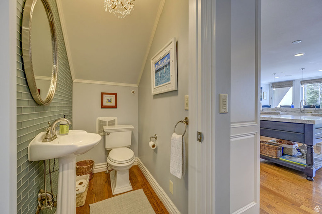 9699 Bypass Road, Unit 5 Alta, UT 84092 - Photo 22 of 54 Pedestal sink with polished nickel faucet, glass subway tile accent wall, hardwood flooring, and a crystal chandelier