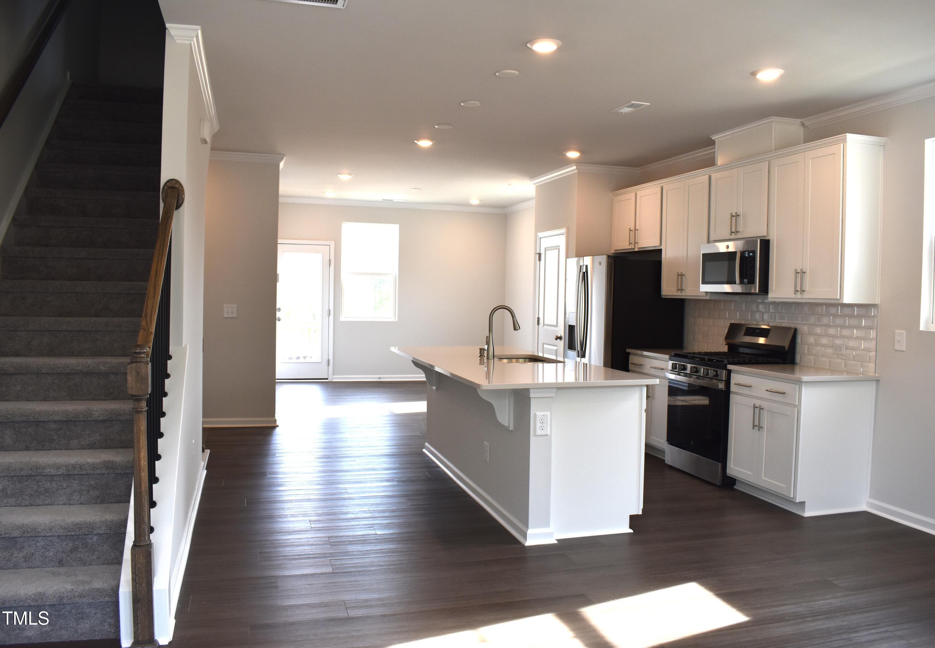 a kitchen with stainless steel appliances a stove top oven and a refrigerator