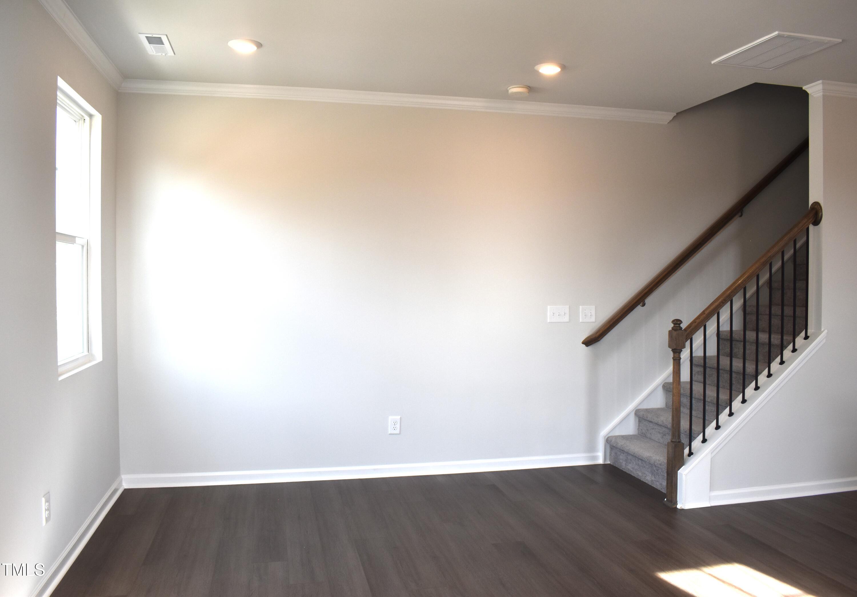 301 Deercroft Drive Apex, NC 27539 - Photo 11 of 33 a view of an empty room with wooden floor and a window