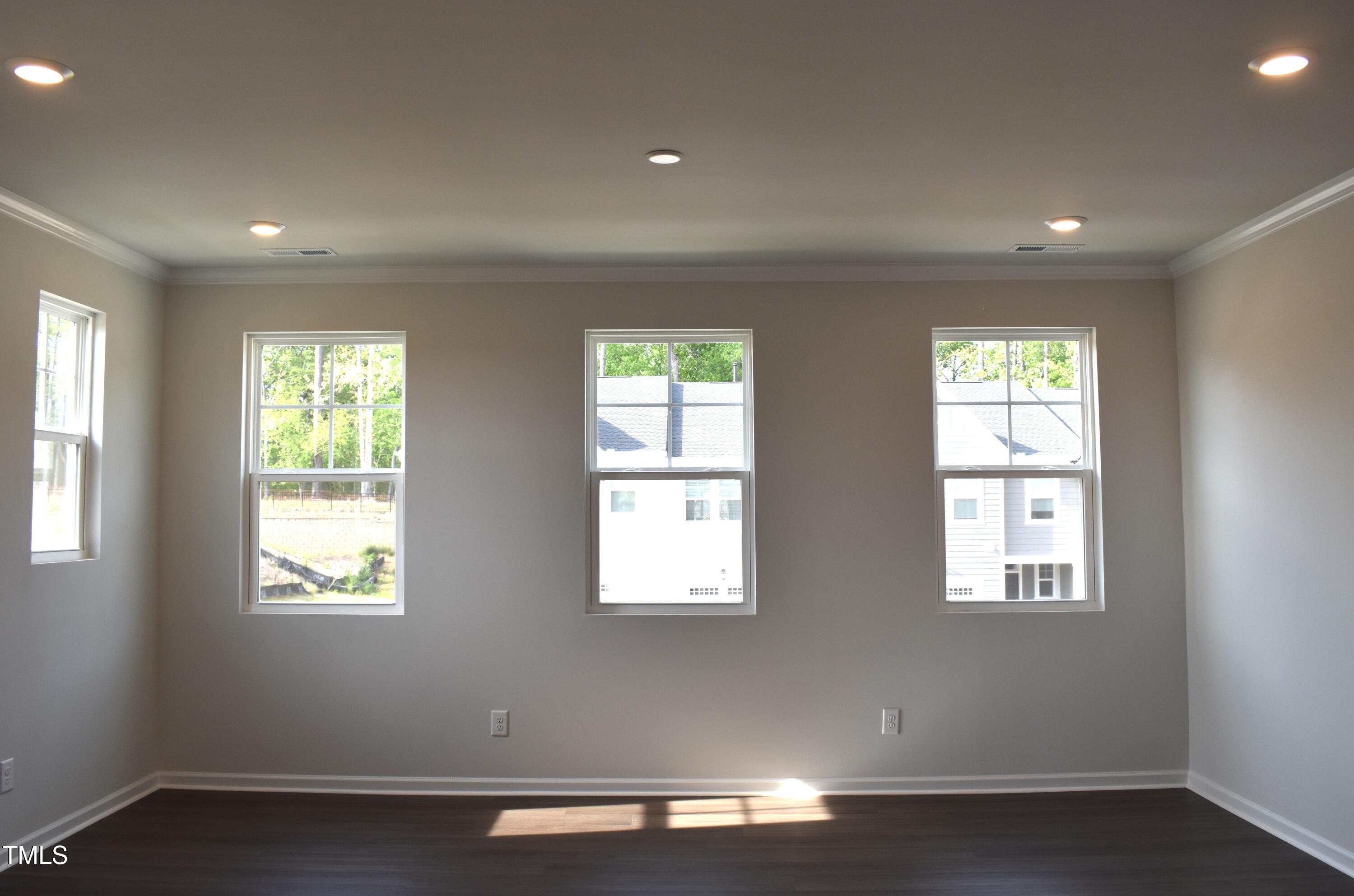 301 Deercroft Drive Apex, NC 27539 - Photo 13 of 33 a view of an empty room with wooden floor and a window