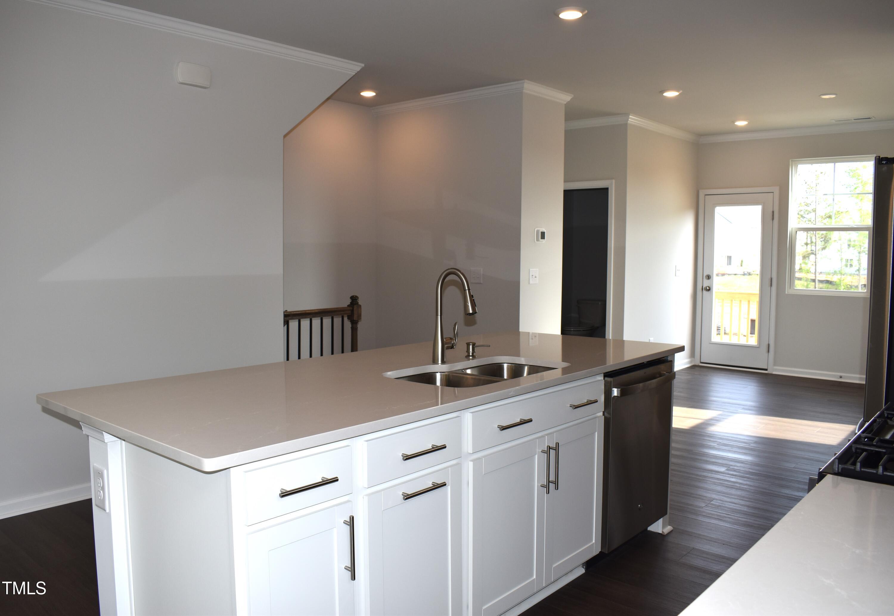 301 Deercroft Drive Apex, NC 27539 - Photo 16 of 33 a kitchen with kitchen island a sink appliances and a counter top