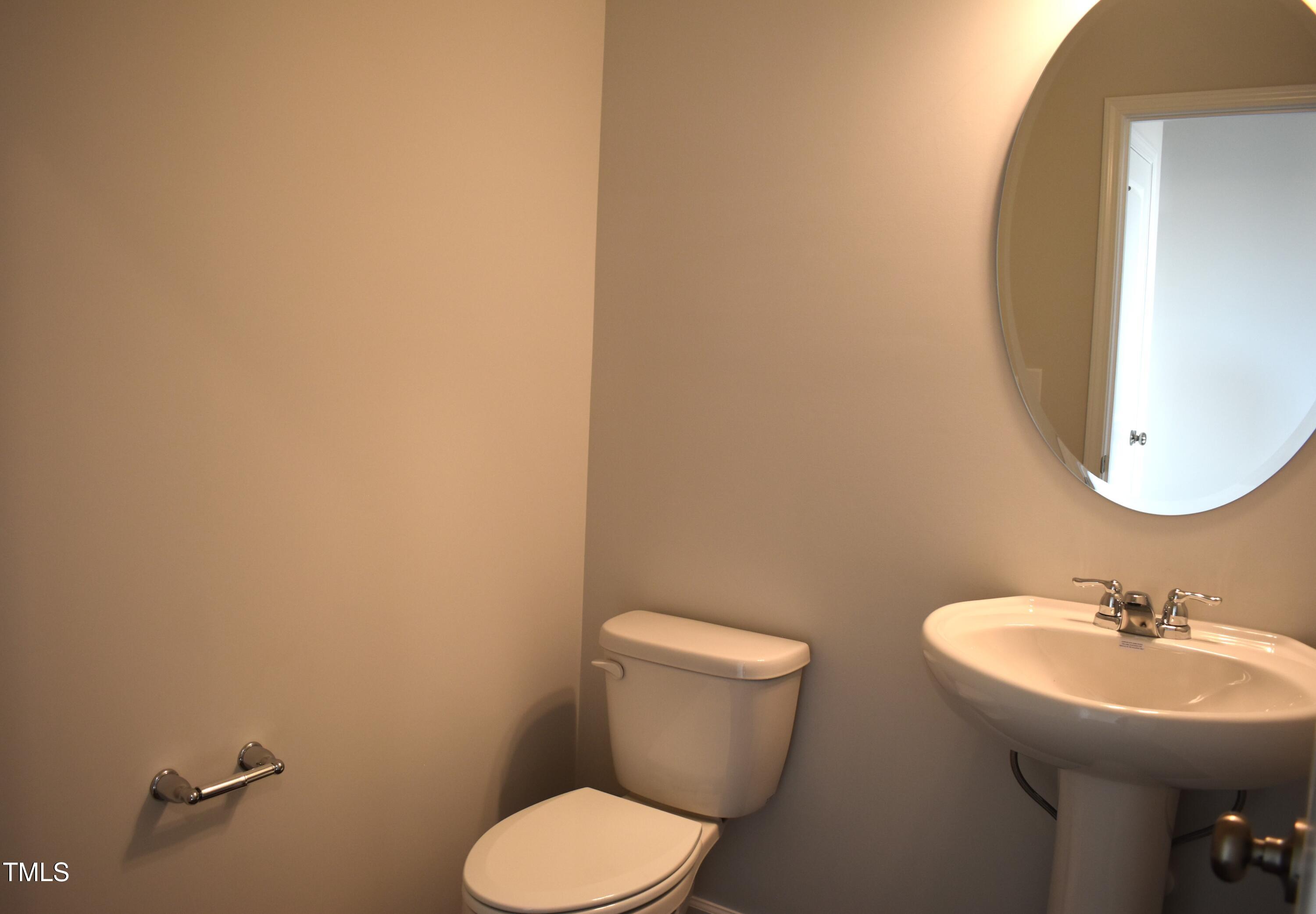 301 Deercroft Drive Apex, NC 27539 - Photo 19 of 33 a bathroom with a toilet sink and mirror