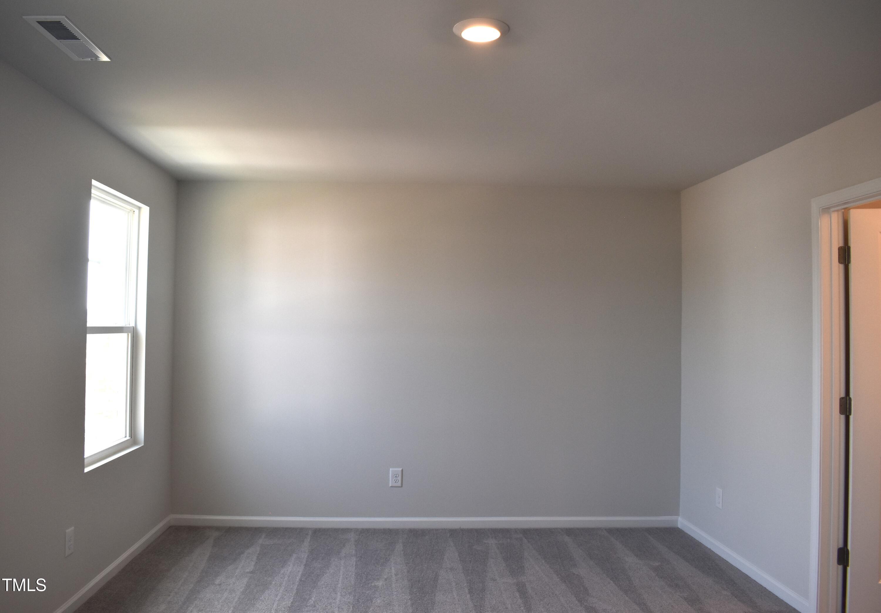 301 Deercroft Drive Apex, NC 27539 - Photo 23 of 33 an empty room with wooden floor and windows