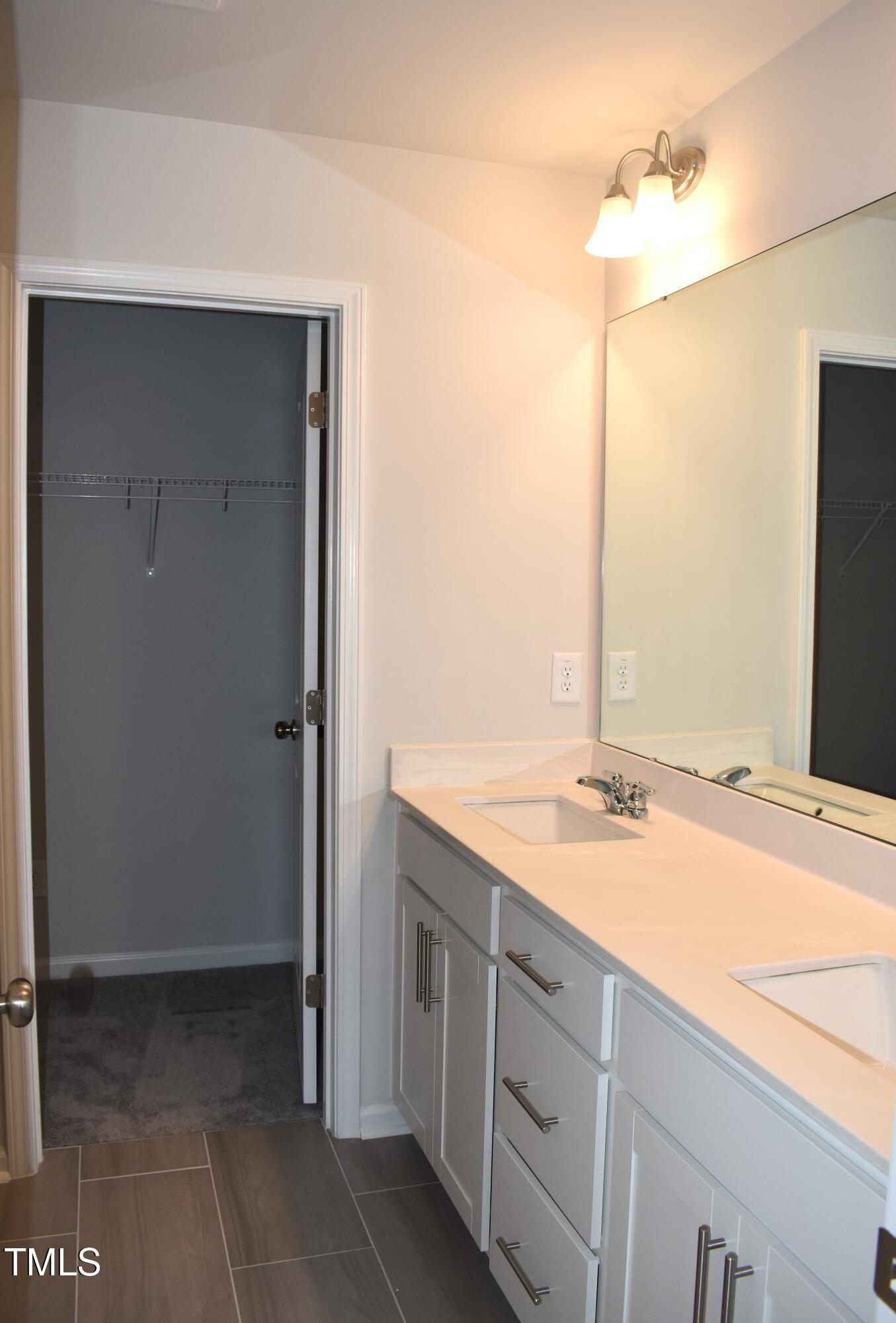 301 Deercroft Drive Apex, NC 27539 - Photo 25 of 33 a bathroom with a granite countertop sink and a mirror