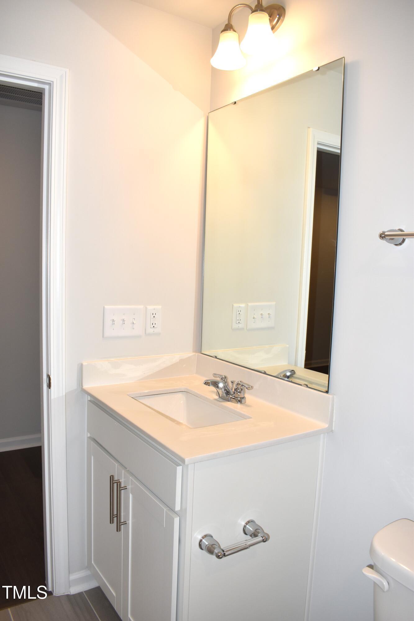 301 Deercroft Drive Apex, NC 27539 - Photo 8 of 33 a bathroom with a sink and a mirror